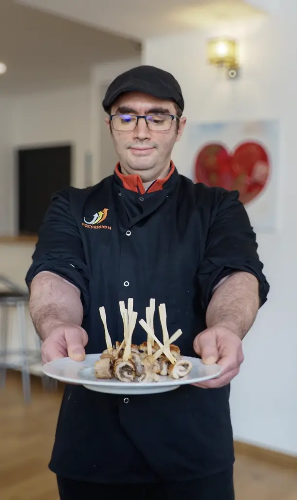 apprenant en cqp boucherie tenant une assiette de sa création et portant une chemise bordée "For'Mission"